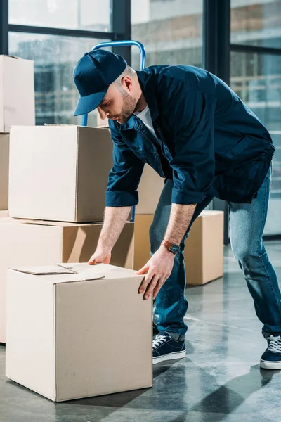 Corriere mettere pacchetto di cartone sul pavimento — Foto stock