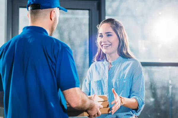 Entrega hombre dando mujer pila de pizzas en cajas - foto de stock