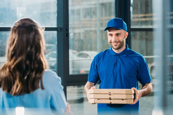 Woman receiving stack of pizzas in boxes from courier — Stock Photo