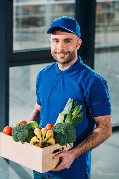 Livraison homme tenant boîte avec épicerie fraîche — Photo de stock