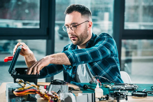 Hardware-Ingenieur auf der Suche nach Werkzeugen am Arbeitsplatz — Stockfoto