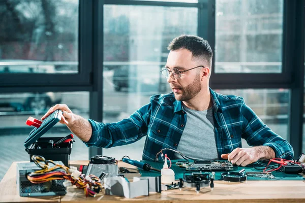 Engenheiro de hardware com instrumentos e placa de circuito no local de trabalho — Fotografia de Stock