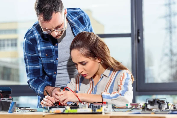 Woman and man engineers testing circuit board — Stock Photo