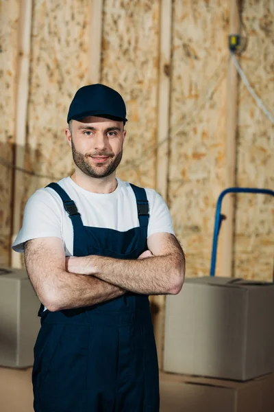 Delivery man looking at camera with arms folded — Stock Photo