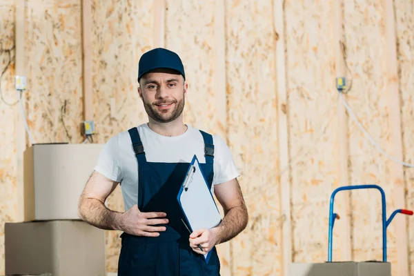 Lächelnder Zusteller mit Frachtbrief — Stockfoto