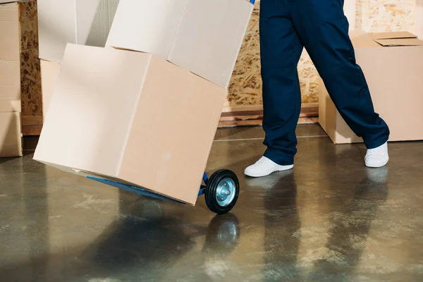 Vue rapprochée du livreur transportant des boîtes sur son chariot — Photo de stock