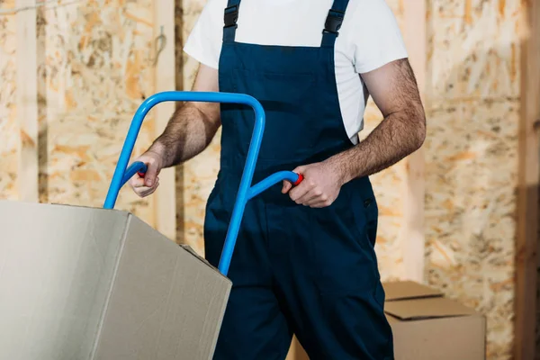 Zusteller schiebt Karren mit Kartons — Stockfoto