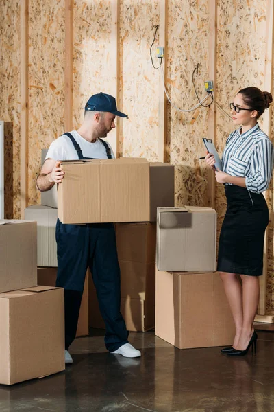 Empresária dando instruções para homem de entrega com caixa — Fotografia de Stock