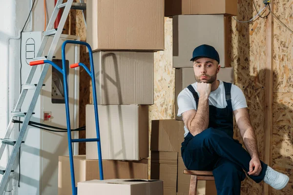 Uomo di consegna annoiato in attesa di pile di scatole — Foto stock