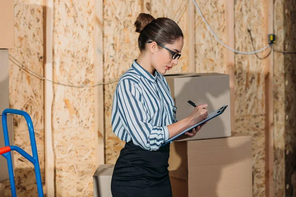 Femme d'affaires avec presse-papiers remplissant la déclaration de fret — Photo de stock