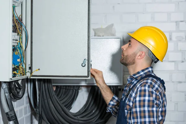 Électricien vérifiant les fils de maintenance des lignes électriques — Photo de stock