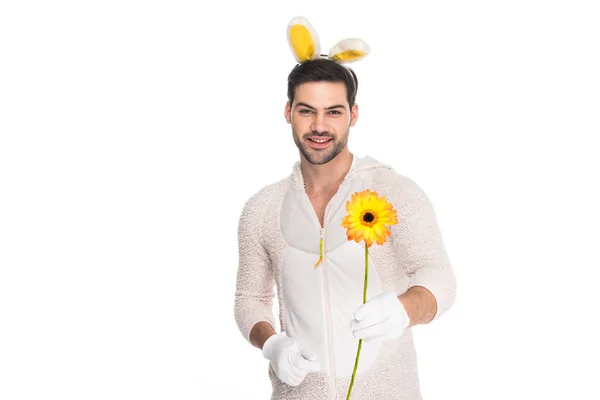 Jeune homme en costume de lapin tenant fleur isolé sur blanc, concept de Pâques — Photo de stock