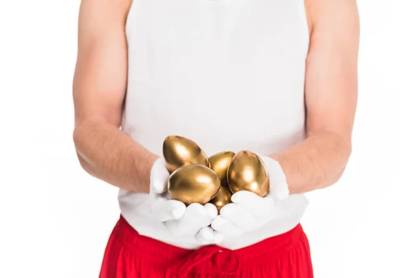 Частичное представление человека с золотыми яйцами, изолированными на белом, пасхальном концепте — стоковое фото