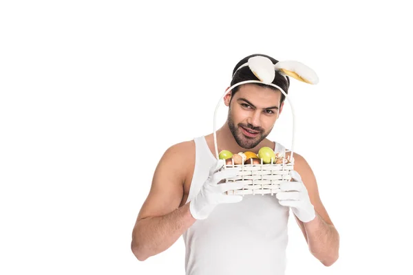 Homme avec des oreilles de lapin tenant panier de fruits isolés sur blanc, concept de Pâques — Photo de stock