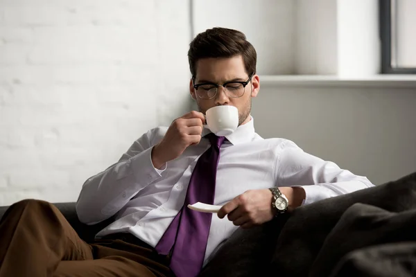 Front view of young businessman drinking coffee — Stock Photo