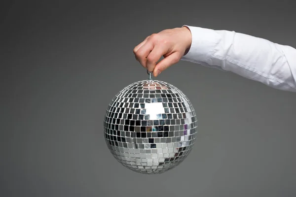 Partial view of businessman hand holding glass disco ball isolated on grey — Stock Photo