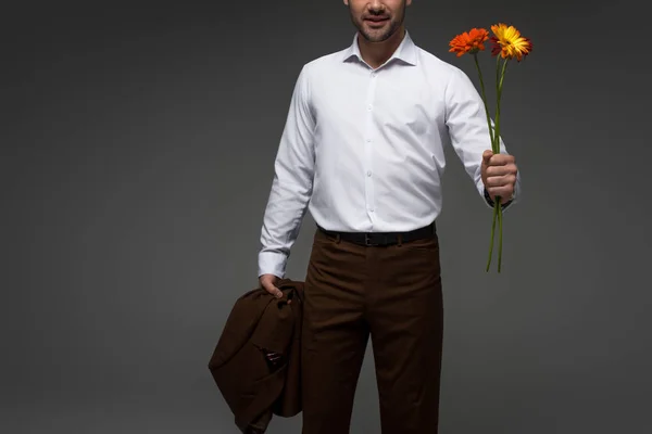 Cropped image of businessman holding bouquet of flowers isolated on grey — Stock Photo