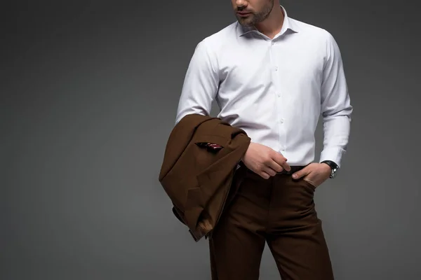 Vista ritagliata di uomo d'affari con le dita in tasca su grigio — Foto stock