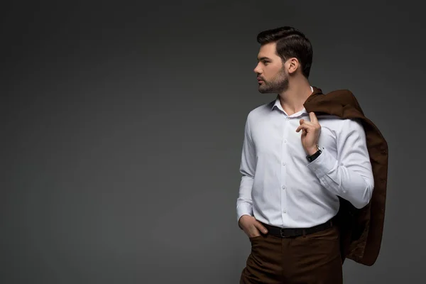Vista laterale di giovane uomo d'affari con giacca sulla spalla isolata su grigio — Foto stock