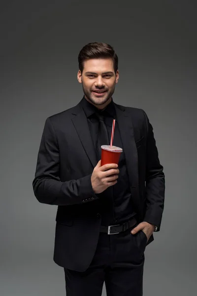 Smiling businessman holding disposable cup isolated on grey — Stock Photo