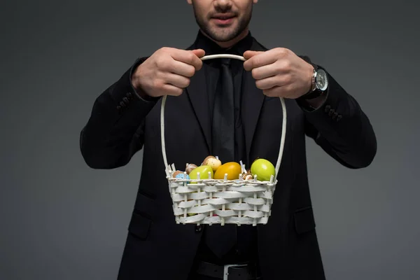 Abgeschnittene Ansicht eines Geschäftsmannes, der einen Korb mit Früchten hält, isoliert auf grau — Stockfoto