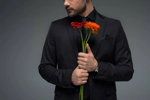 Vista recortada de macho con ramo de flores aislado en gris, concepto de día internacional de la mujer - foto de stock