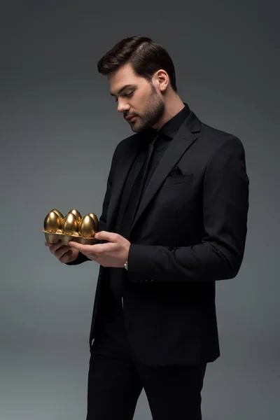 Profile of male holding golden eggs isolated on grey, easter concept — Stock Photo