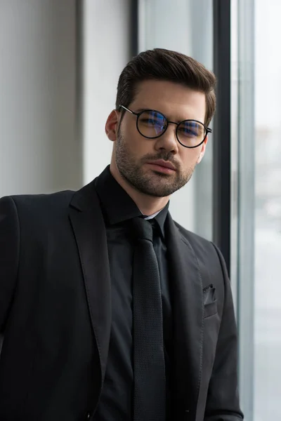 Porträt eines stilvollen Geschäftsmannes mit Brille, der in die Kamera blickt — Stockfoto