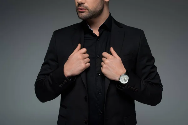 Ausgeschnittene Ansicht eines Mannes im schwarzen stylischen Anzug isoliert auf grau — Stockfoto