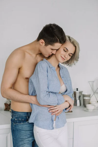 Sedutor jovem casal abraçando na cozinha — Fotografia de Stock