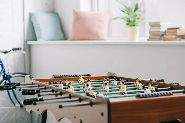 Table football and bicycle in living room — Stock Photo