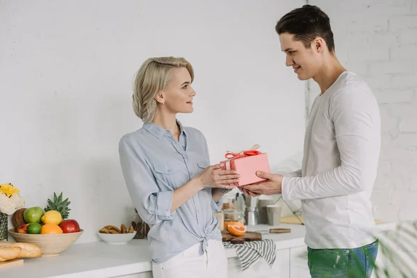 Fidanzato presentazione fidanzata regalo su 8 marzo in cucina — Foto stock