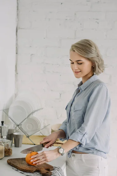 Belle fille coupe pamplemousse à la cuisine — Photo de stock