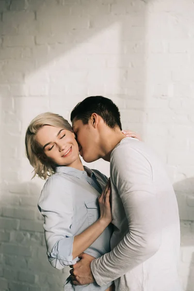 Boyfriend kissing girlfriends neck at home — Stock Photo