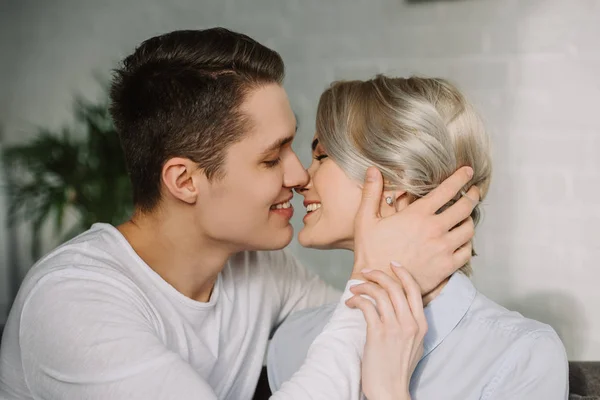 Sexy sonriente pareja besándose en casa - foto de stock