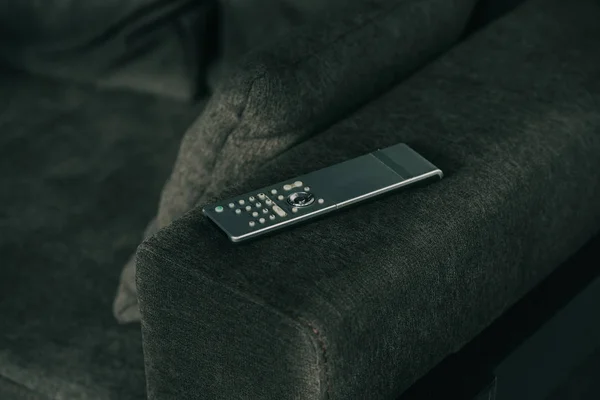 Télécommande sur canapé gris foncé — Photo de stock