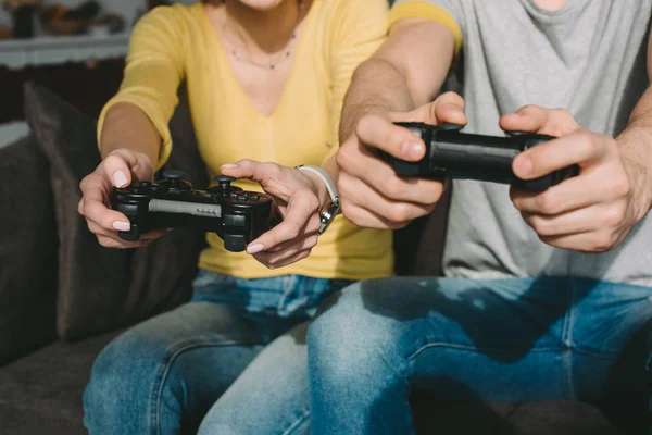 Imagen recortada de pareja jugando videojuego en casa - foto de stock