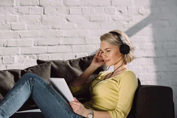 Attraktives Mädchen, das zu Hause mit dem Tablet Musik hört — Stockfoto