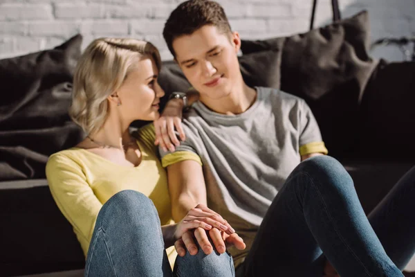 Couple sitting on floor and holding hands at home — Stock Photo