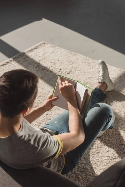 Vista ad alto angolo del libro di lettura dell'uomo a casa — Foto stock