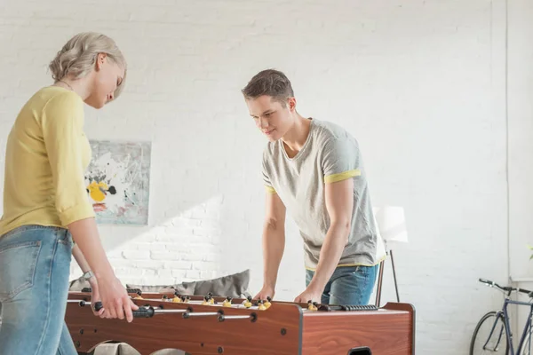 Couple playing table soccer in living room — Stock Photo