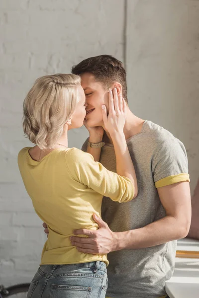 Sensual pareja de pie y besándose en casa - foto de stock