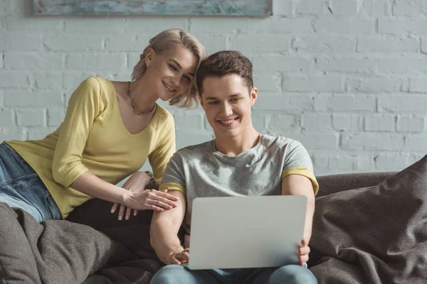 Happy couple looking at laptop at home — Stock Photo