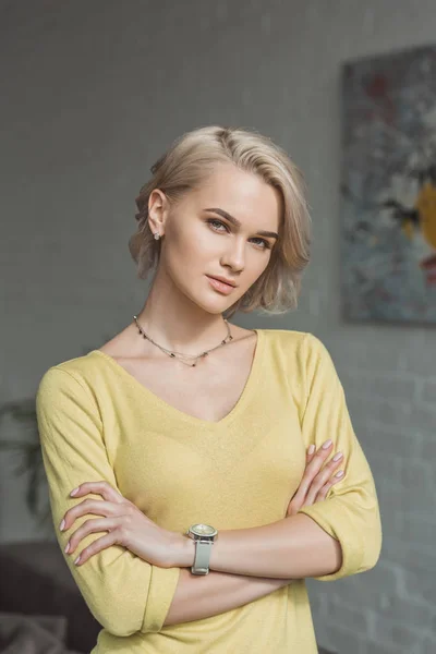 Beautiful girl standing with crossed arms and looking at camera — Stock Photo