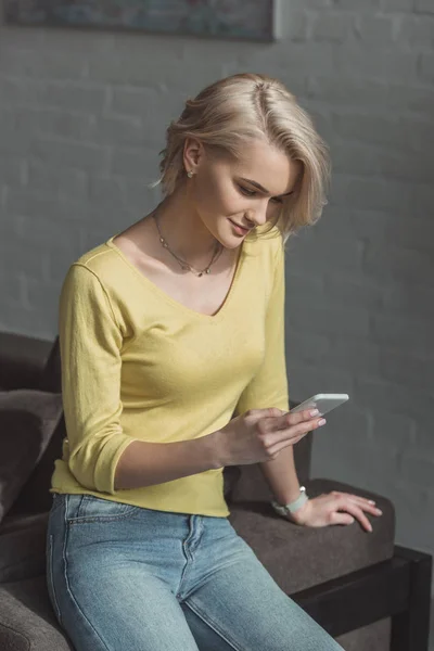 Hermosa chica usando teléfono inteligente en casa — Stock Photo