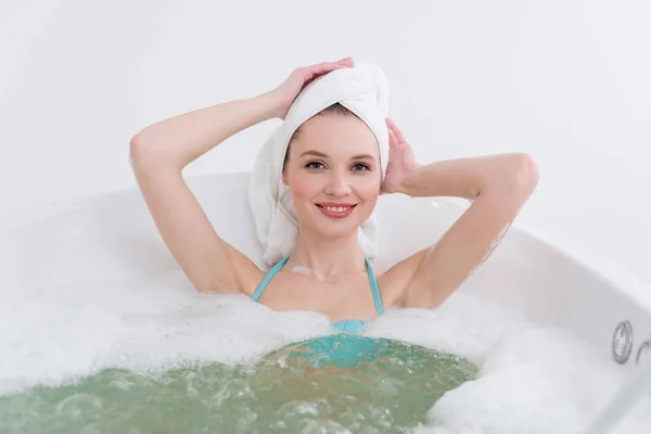 Femme attrayante avec serviette sur la tête relaxant dans la salle de bain dans le salon de spa — Photo de stock
