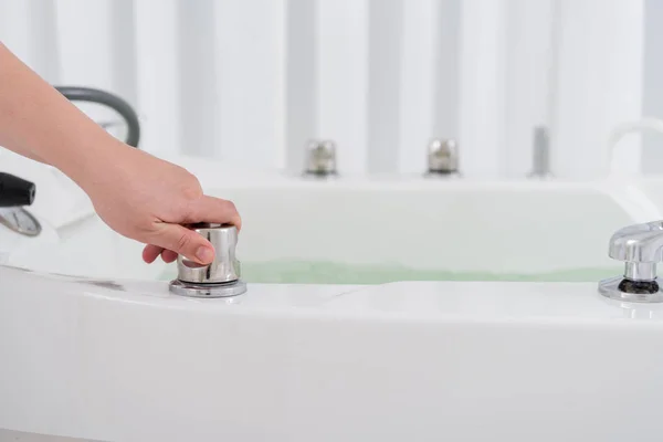 Colpo ritagliato di assistente salone spa regolando l'acqua nel bagno idroelettrico — Foto stock