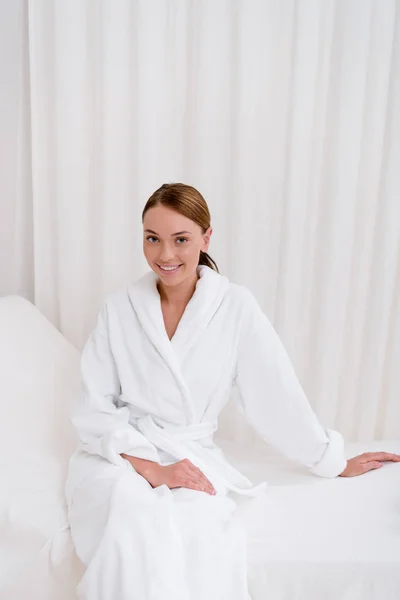 Jeune femme séduisante en peignoir blanc reposant dans le salon de spa — Photo de stock