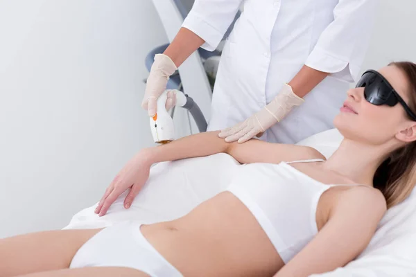 Plan recadré de la femme obtenant la procédure d'épilation au laser sur le bras dans le salon — Photo de stock