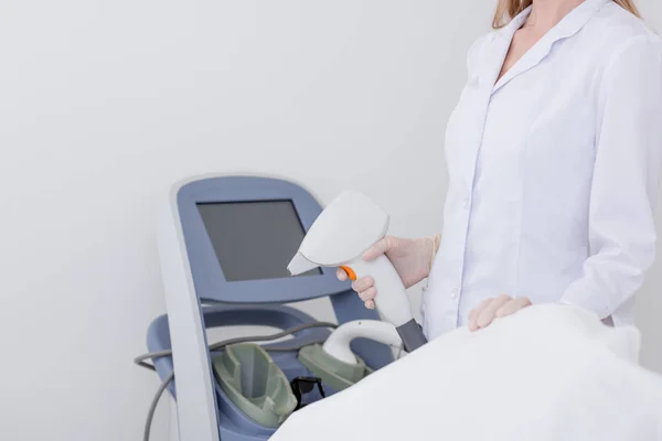 Cropped shot of cosmetologist with laser hair removal apparatus in salon — Stock Photo